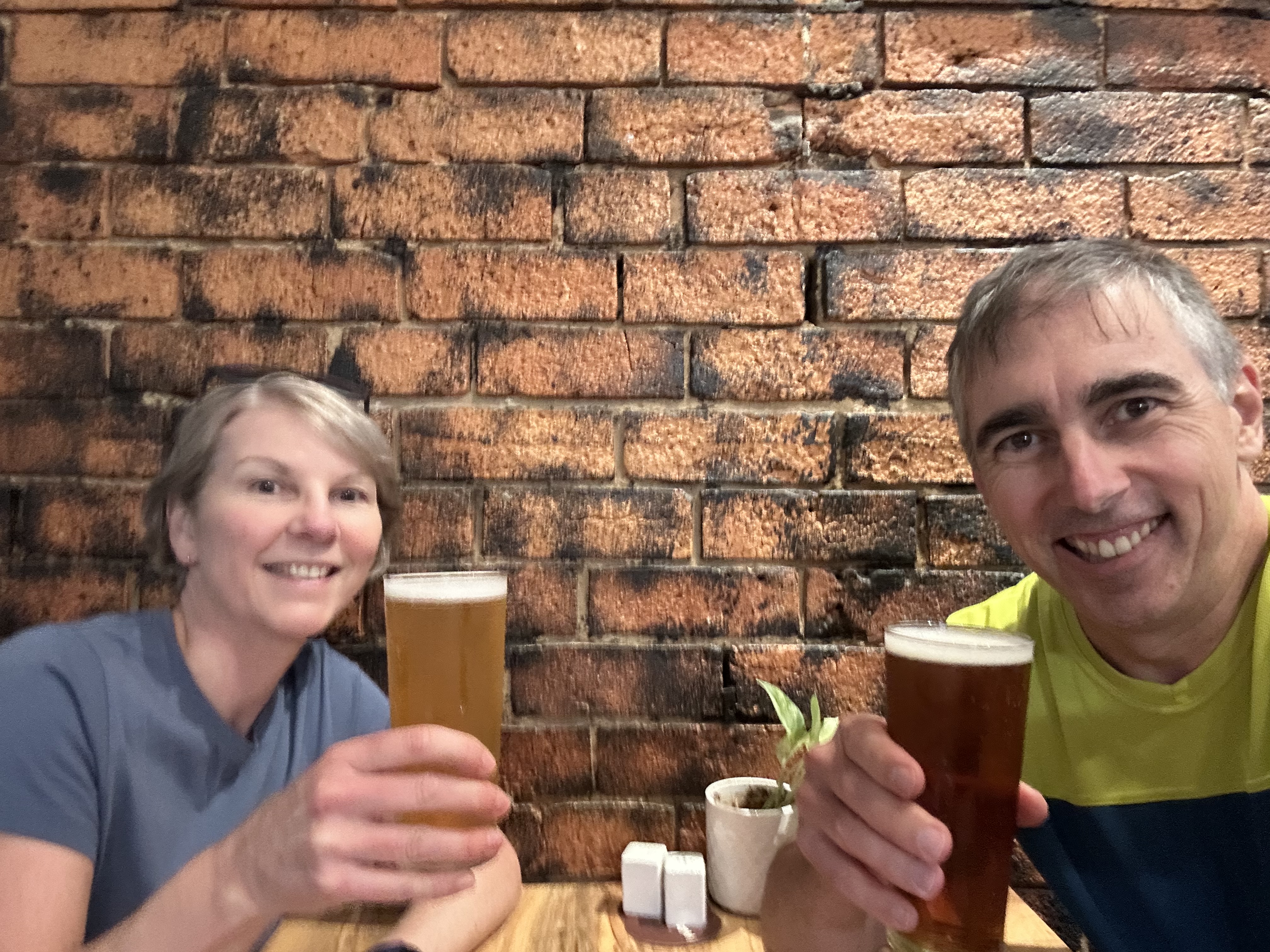 Linda and Jason smiling with beers